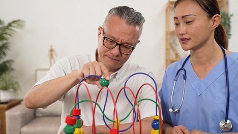 Patient concentration on bead movement device with a healthcare worker next to them